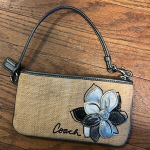 Small Coach Wristlet with wicker & silver handle with decorative flower.